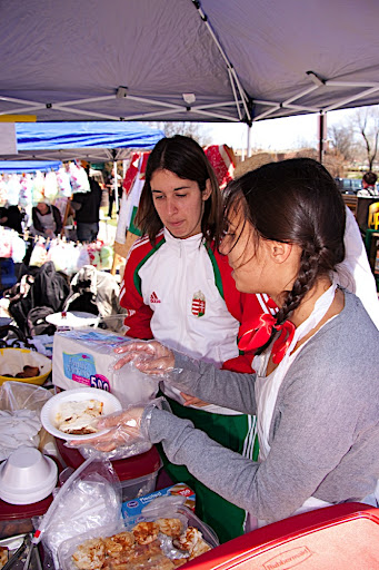 Erika and Kisa serving food and taking cash.