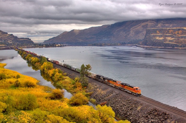 A west bound BNSF manifest train crosses the fill at Chamberlain Lake near Lyle, Washington.