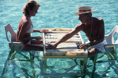 Carmen Alvarez enjoying a game of backgammon with Frank 'Brandy' Brandstetter in a swimming pool at Acapulco.   (Photo by Slim Aarons/Getty Images)