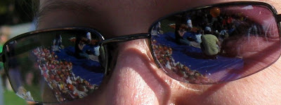 Sunglasses, reflecting the view of people painting pumpkins.