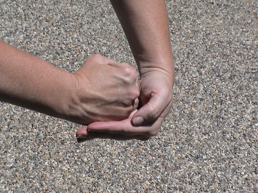 Grasp the fist with your other hand similar to the Heimlich technique. Grasp the fist with your other hand similar to the Heimlich technique.