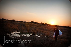 Groom carrying bride over bridge in setting sun - Joretha Taljaard Wedding Photography
