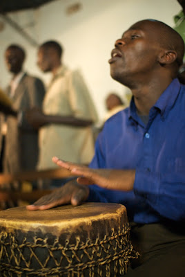 Man singing and playing drum