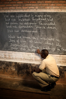 Phanuel Munezero writes 2 Corinthians 4 on chalkboard