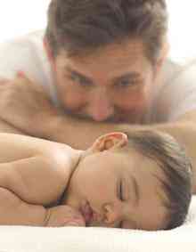 A man examination his baby sleep