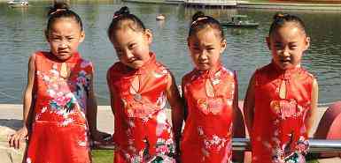 Quadruplets poise as they stick on hundreds of Chinese twins during the 6th Beijing Twins Festival