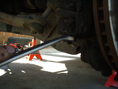 Removing the outer tie rod end nut.  You can see the brake rotor which is attached to the spindle by the hub.  This joint is what pushes the wheel to turn when you turn the wheel.