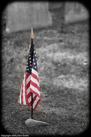 Remember'd: A flag, placed next to a stone so heavily weathered that no trace of word or prose remains. (1/2500 sec @ f/1.8; 50mm) Copyright 2009, Kerri Shotts