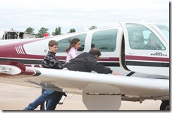 Auburn Hughes, 8,  and Shelby Hughes, 11, climb into a Beechcraft Bonanza piloted by Neosho Mayor Richard Davidson during a fundraiser for Kyle and Amanda Franklin on Saturday. 
