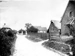 Upton School. A view along the road that runs past the school towards the church, with three children sitting on the grass verge outside the school railings. Copyright © Oxfordshire County Council Photographic Archive. Reproduced with the kind permission of Oxfordshire Studies. This photograph may be purchased from their Heritage Search web site at http://www.oxfordshire.gov.uk/heritagesearch
