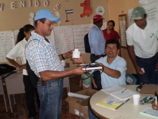 Luis Lanzas gives a solar lamp to an AVODEC member.