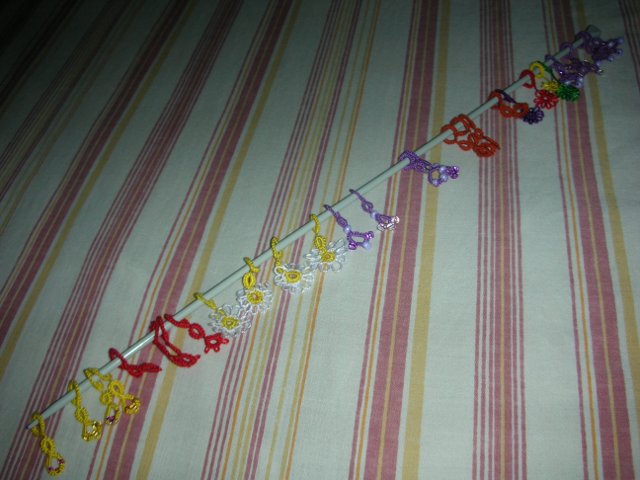 Many stitch markers on a needle.