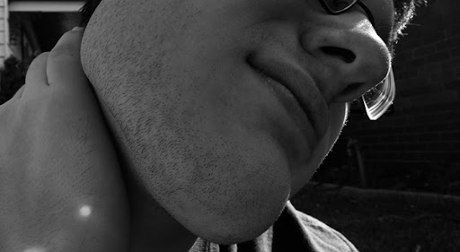 A man holding back of his neck because of muscle ache at his neck.