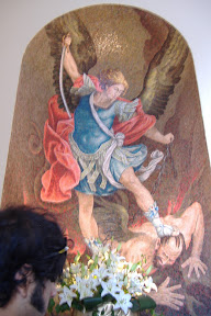 One guy with wings (an angel? Devil?) getting beat down by another guy with wings and a sword.