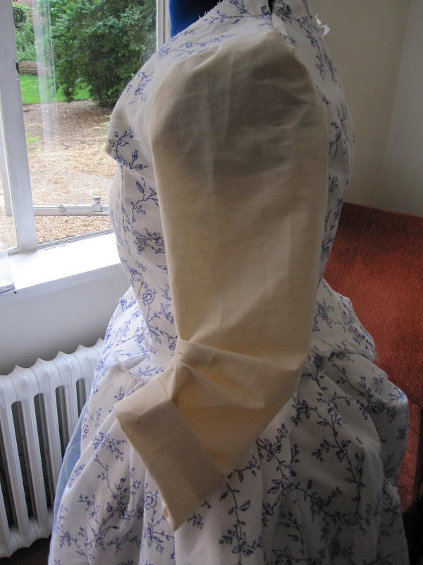Sleeve pined to make a bend at the elbow and folded back to make a cuff Sleeve pined to make a bend at the elbow and folded back to make a cuff