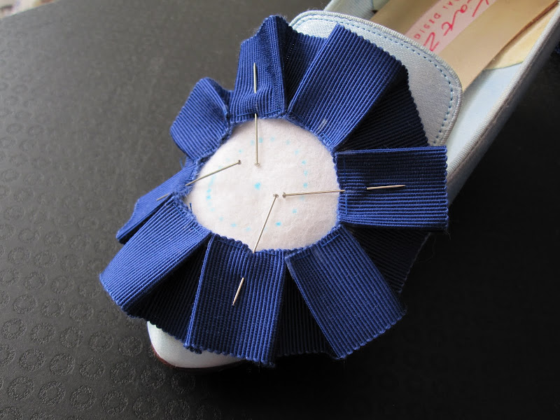 Box pleats pinned on to the felt circles. Checking the size on the shoe. Box pleats pinned on to the felt circles. Checking the size on the shoe.