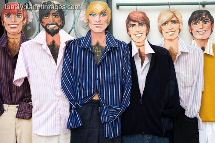 six hairy chested mannequins with different hair colors in a shop window