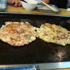Unos Okonomiyaki, una mezcla entre una pizza y un hot-cake. Esta hecho de pasta de arroz con vegetales y pescado o mariscos. El de la derecha es de vegetales y el de la izquierda es mucho más carnivoro :D