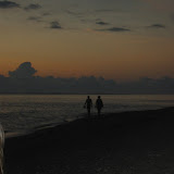 Ein Pärchen bei einem romantischen Spaziergang am Strand bei Sonnenuntergang