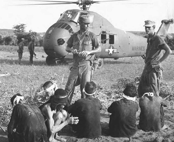Viet Cong prisoners captured during Operation Starlite await transfer by helicopter to a prisoner-of-war camp in August 1965. The Marine search-and-destroy operation south of Chu Lai resulted in 599 Viet Cong casualties. 