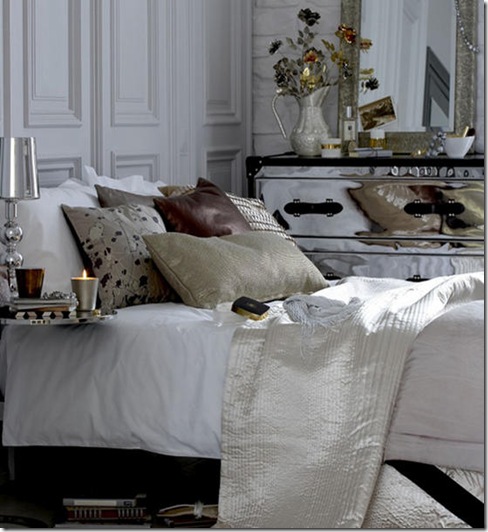 Bedroom painted exposed bare brick wall moulded wood panelled wall assorted metalic fabric cushions bedspread throw chrome chest of drawers L etc 11/2007 Pub Orig
