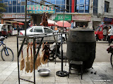 Vista exterior del montaje asador de patos. En el colgadero esperan los que estan crudos todavia, y los ya asados, bajan la temperatura antes de ser devorados.