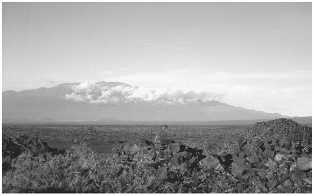 The ruins of the highest heiau in Hawai'i, Ahu a 'Umi, at an elevation of 1600 meters (5250 feet) in the saddle of the Big Island, viewed from the first of two different angles. In the background of this view is Mauna Kea with the modern observatory at its summit. 