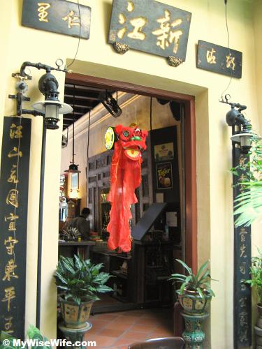 The plaque above lion head reads Sin Kang represents ancestral village of Khoo family The plaque above lion head reads Sin Kang associated with ancestral village of Khoo family