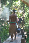 Native indian with wood incense crossing the marsh on a wooden bridge Caraiva, Brazil