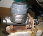 With the brake line connection on the front end of the master cylinder, I may have to modify the front plate of the cover, but not by much.