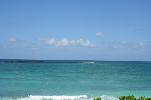 a body of water with rocks and blue sky