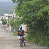 Jody tackles the hill up to the current Mak House. It's much easier on a moto than walking.