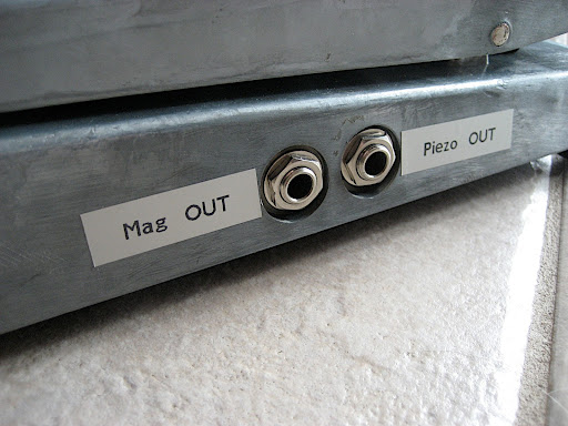 Dual-mono TS output. A centre detent in the blend pot allows the player to feel the point where both signals are at 100% volume. Pushing forward rolls off the piezo signal, pulling back rolls off the magnetic signal to zero.
