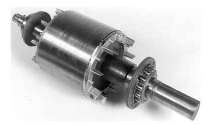 Cage rotor for induction motor. The rotor conductor bars and end rings are cast in aluminium, and the blades attached to the end rings serve as a fan for circulating