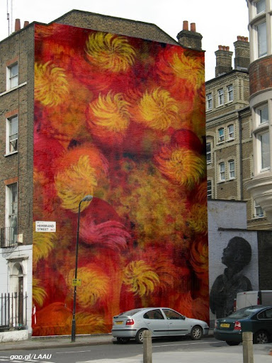 Victor Angelo large gold red orange yellow painting on the side of brick building