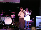 Sid Linver talks to the crowd and presents a plaque to Julia at Party With a Purpose