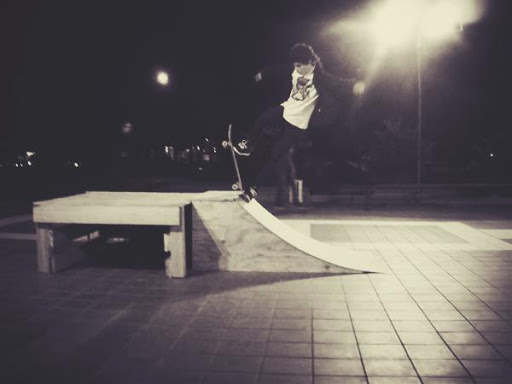 Kid in the park skating on a youth center skate ramp.