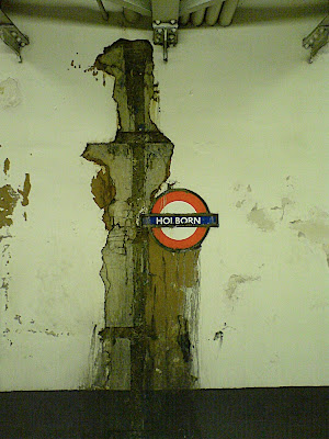 damaged wall around Tube sign