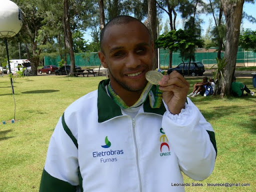 Na foto, Felipe Gomes exibe a medalha de ouro. Atrás dele, se vêem árvores