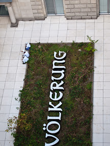 [KÖCHE IM LICHTHOF DES REICHSTAGSGEBÄUDES IN BERLIN AN DER KUNST-INSTALLATION "DER BEVÖLKERUNG" SITZEND]