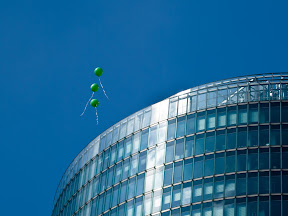 [3 GRÜNE, FLIEGENDE LUFTBALLONS VOR DER SPITZE DES BAHNTOWERS IN BERLIN AM POTSDAMER PLATZ]
