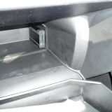 The cable snakes between the glove box door hinge and disappears into the center column trim.