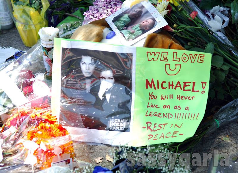 Mourners gather outside of the home of Michael Jackson in Los Angeles, California on June 26, 2009 to deliver cards, banners and flowers.