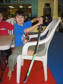 Kai shows off the frosting on the sword after cutting his cake with it