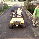 Kai and Eidan riding on the neighbor's battery powered mini Jeep Kai and Eidan riding on the neighbor's battery powered mini Jeep
