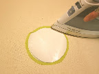 Fold the excess fabric over the two paper circles, and press in place (the fabric will stick to the top circle). If a bump shows up, simply lift the fabric and press again - freezer paper allows repositioning.