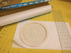 Fold a piece of freezer paper in half, and cut a circle using a circle cutter or bowl as a guide. You will end up with TWO perfect freezer paper circles.