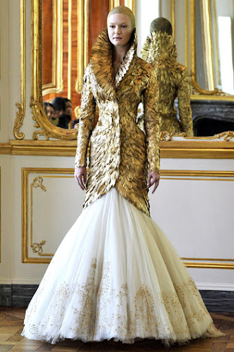 Ensemble of coat of duck feathers painted gold and skirt of white silk embroidered with gold thread (Fall/Winter 2010-2011) Ensemble of coat of duck feathers painted gold and skirt of white silk embroidered with gold thread (Fall/Winter 2010-2011)