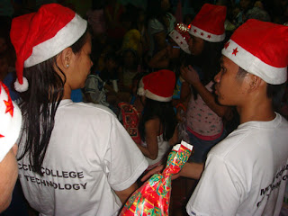 MCCID Santa Clauses' Joanna and Ariel assists in giving out gifts.