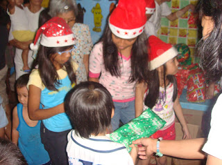 Esposa Kids Patricia, Mariegin and Regina Mae together with MCCID Registrar Ma'am Remedios Esposa assists in giving out toys and gifts.